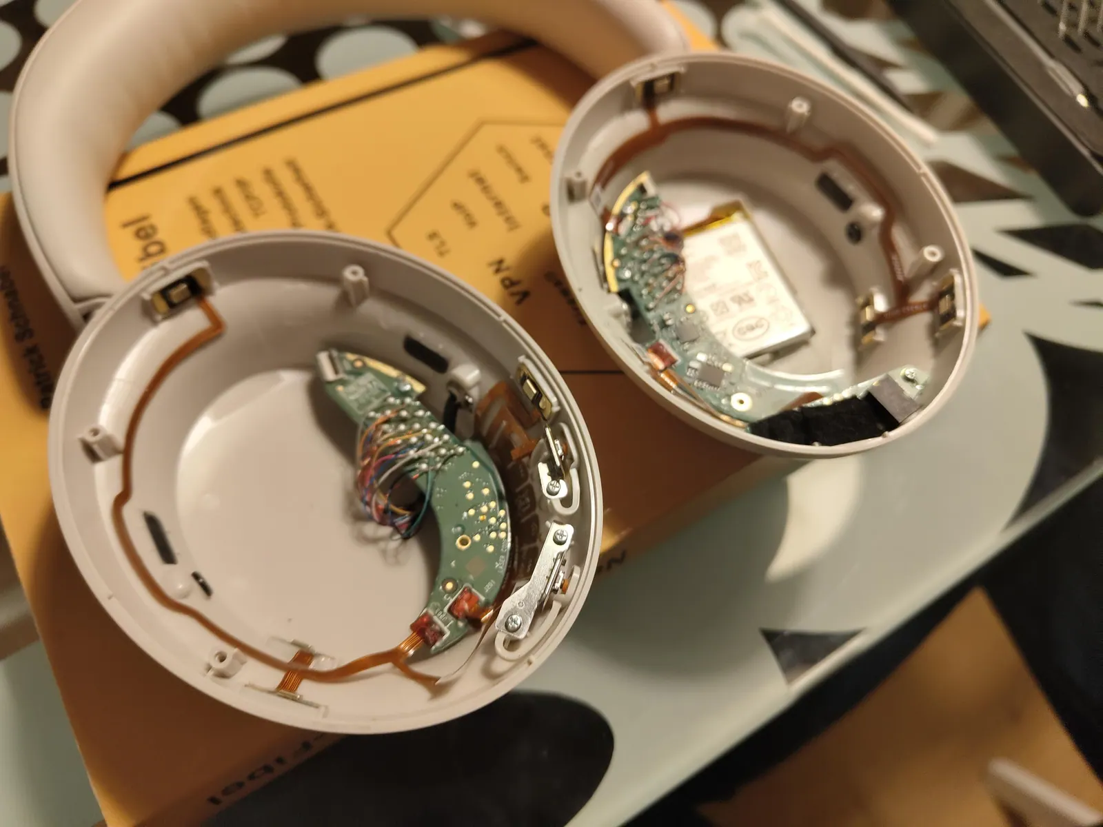 Hai bên vỏ tai nghe chống ồn tháo rời, lộ bo mạch, cáp nối micro và pin
